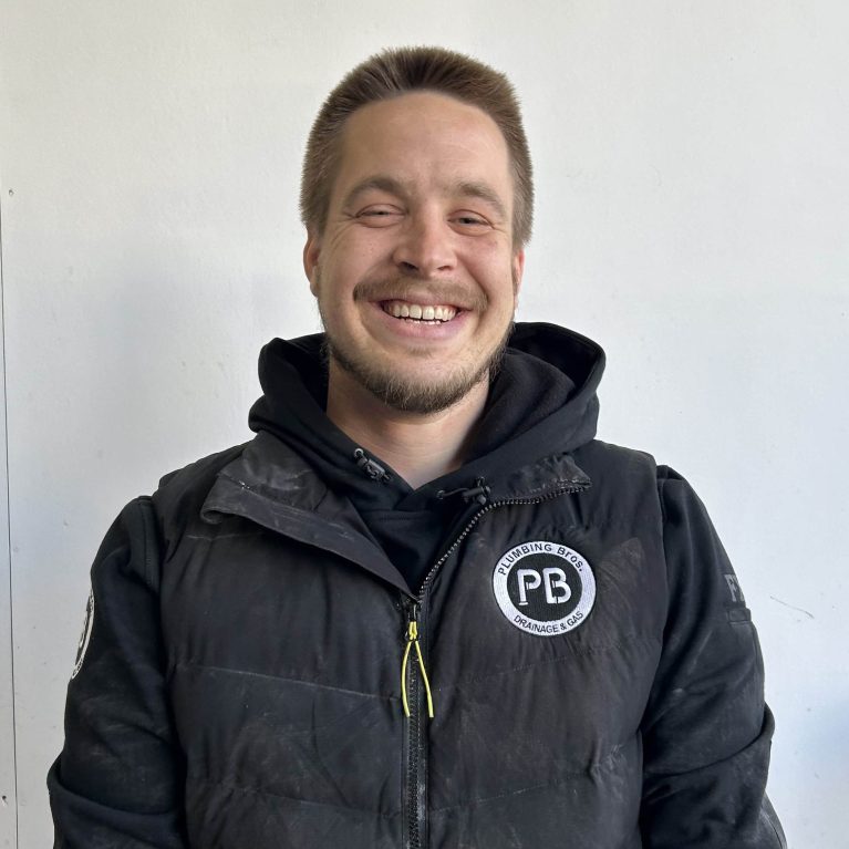 Photograph of plumber Austin from Plumbing Bros Chatswood, wearing a black uniform