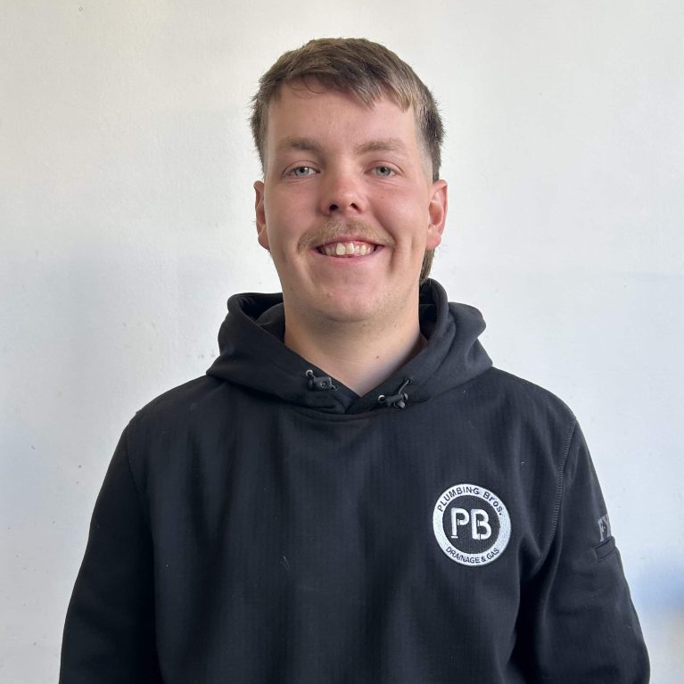 Photograph of plumber Austin from Plumbing Bros Chatswood, wearing a black uniform